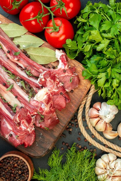 Ansicht von oben rohe Fleischscheiben mit Gemüse auf dunklem Hintergrund braten Metzger Essen Gericht Mahlzeit Salat Fleisch kochen