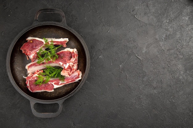 Ansicht von oben rohe Fleischscheiben mit Gemüse in der Pfanne auf dunklem Hintergrund rohes Kuhfoto Pfeffer Hühnerfleisch Farbe tierfreier Raum