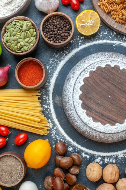 Ansicht von oben verschiedene Zutaten Eier Nüsse Gemüse Nudeln und Gewürze auf dunklem Hintergrund Mahlzeit Zucker Kuchen Foto Farbe Diät Gebäck Essen