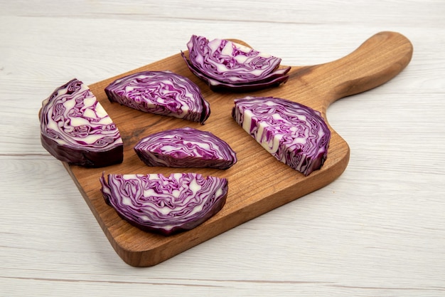 Kostenloses Foto ansicht von unten gehackter rotkohl auf holzbrett auf weißer oberfläche