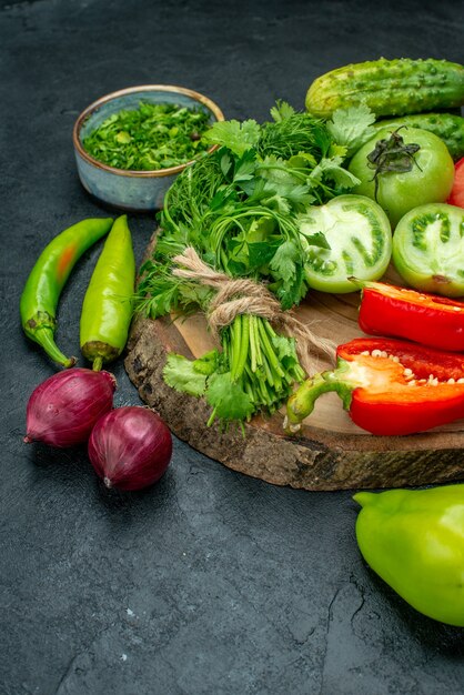 Ansicht von unten Gemüse Tomaten Paprika Gurken Grüns auf Holzbrett Peperoni rote Zwiebeln auf schwarzem Tisch