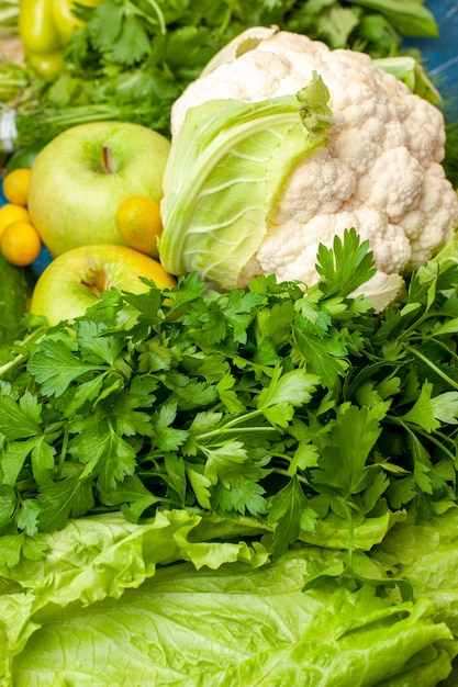 Kostenloses Foto ansicht von unten gemüse und obst petersilie salat cumcuat koriander blumenkohl äpfel auf dem boden