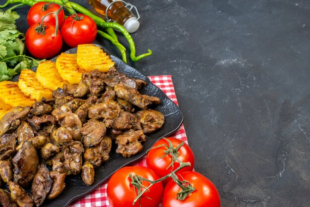 Ansicht von unten Hühnerleber braten mit Kartoffeln auf Teller Tomaten heiße grüne Paprika Ölflasche Koriander auf Tischkopierplatz