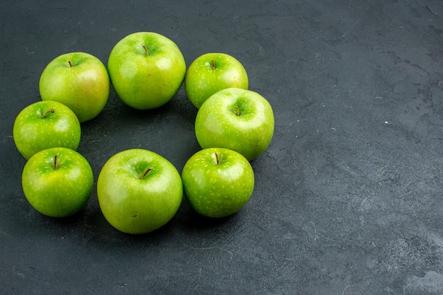 Ansicht von unten Kreisreihe grüne Äpfel auf dunkler Oberfläche mit freiem Platz free