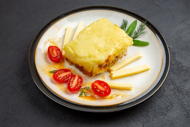 Ansicht von unten leckere Lasagne-Kirschtomaten auf runder Platte auf dunklem Hintergrund