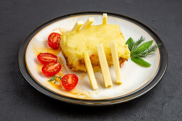 Ansicht von unten leckere Lasagne-Kirschtomaten auf Teller auf dunklem Hintergrund