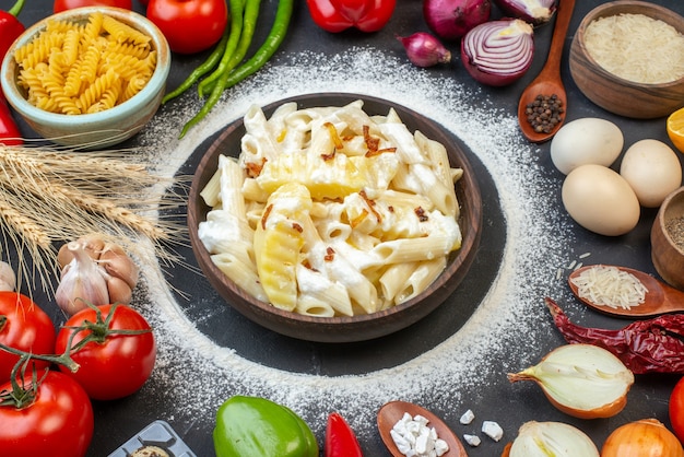 Ansicht von unten leckere Penne Nudeln in Schüssel Tomaten rohe Spiralnudeln und Reis in Schüsseln Eier auf dem Tisch