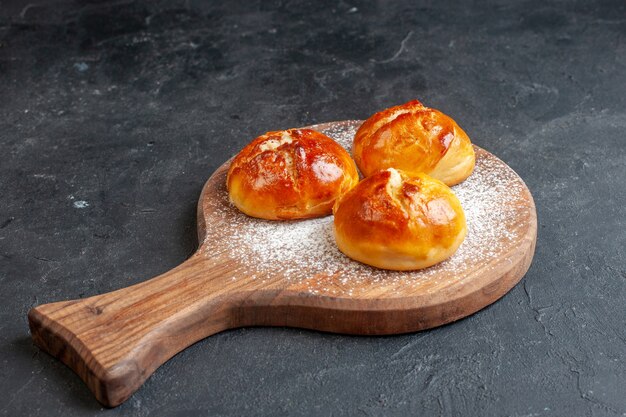 Ansicht von unten leckeres Abendessen Brötchen auf Holzbrett an schwarzer Wand