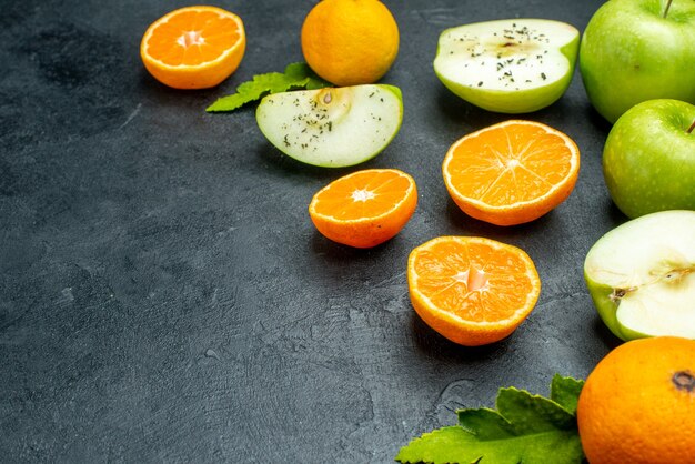 Ansicht von unten Äpfel und Mandarinenscheiben Blätter auf schwarzem Tisch mit Kopierraum