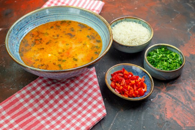 Ansicht von unten Reissuppe in Schüssel auf rot-weiß kariertem Tischtuch andere Sachen in Schüsseln auf dem Tisch