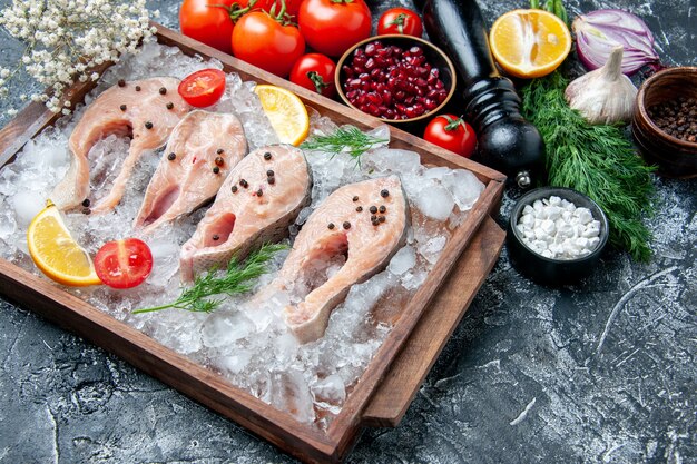 Ansicht von unten rohe Fischscheiben mit Eis auf Holzbrettschalen mit Granatapfelkernen Meersalz schwarz