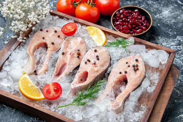 Ansicht von unten rohe Fischscheiben mit Eis auf Holzbrettschalen mit Granatapfelkernen Tomaten kleine Blumen auf dem Tisch