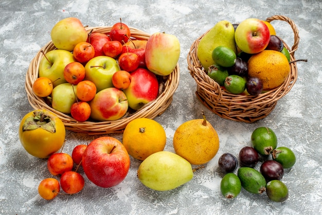 Ansicht von unten rote und gelbe Äpfel und Pflaumen Feykhoas Birnen und Kakis in den Weidenkörben und auch auf dem Boden
