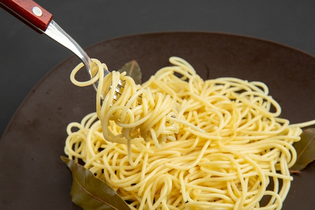 Ansicht von unten Spaghetti Pasta Gabel auf Teller auf schwarzem Hintergrund