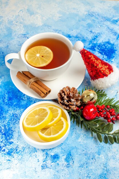 Ansicht von unten Tasse Tee Zitronenscheiben Weihnachtsmütze auf blauem Tisch