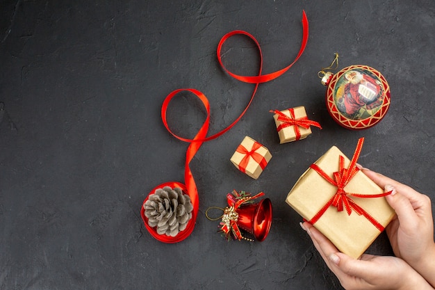 Ansicht von unten weihnachtsgeschenke in braunem papierband weihnachtsbaum spielzeug auf zeitung auf beige