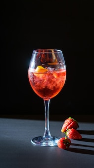 Aperol spritz roter aperitif-cocktail im glas mit eis auf schwarzem hintergrund