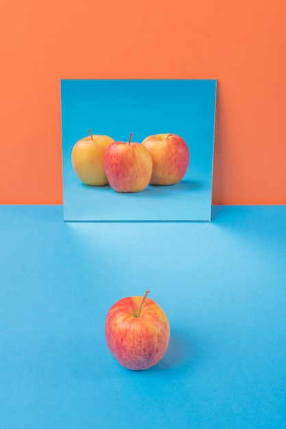 Apfel auf blauem Tisch lokalisiert auf Orange