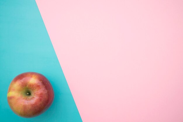 Apfel auf blauem und rosa Hintergrund