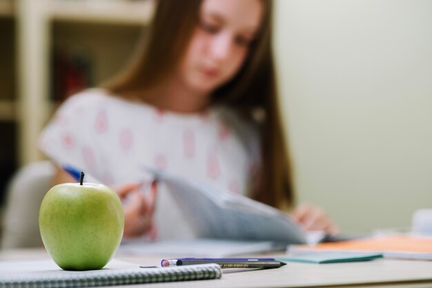 Apfel auf Schreibtisch des Studenten