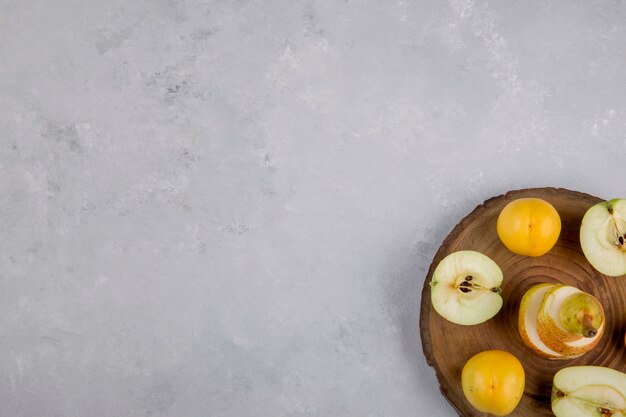 Apfel, Birne und Pfirsiche auf einem Stück Holz, Draufsicht