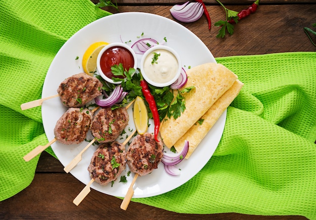 Appetitanregender koftakebab (fleischklöschen) mit soße und tortillatacos auf einer weißen platte