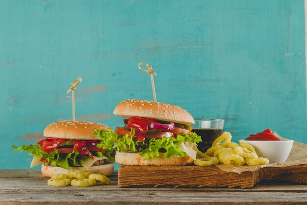 Appetitliche Burger mit Zwiebelringen und trinken