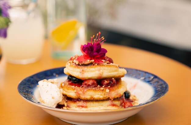 Appetitliche Pfannkuchen dekoriert mit Beeren und Blumen