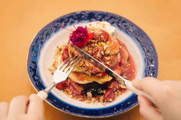 Appetitliche Pfannkuchen dekoriert mit Beeren und Blumen