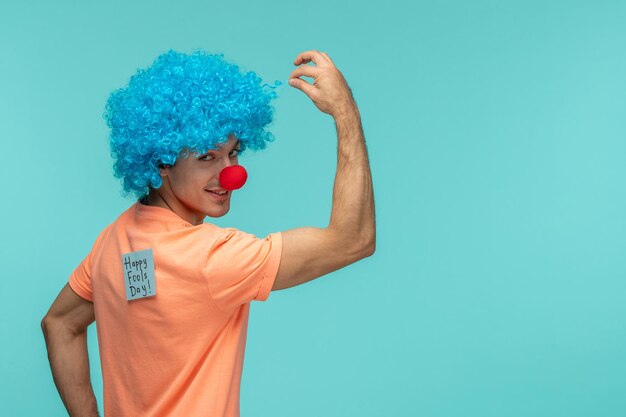 Aprilscherz-Tageskerl-Clown stark, der Bizeps blaue Haare blaue Post-Itaufkleber-Anmerkungs-lustige rote Nase zeigt