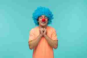 Kostenloses Foto aprilscherzkerl clown glücklich aufgeregt fäuste zusammen unter kinn blaue haare lustige rote nase