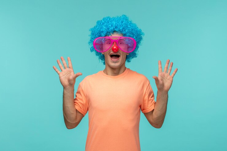 Kostenlose Foto aprilscherztag typ aufgeregt abgestreift rosa sonnenbrille rote nase blaue haare clown lustige hände nach oben zeigen