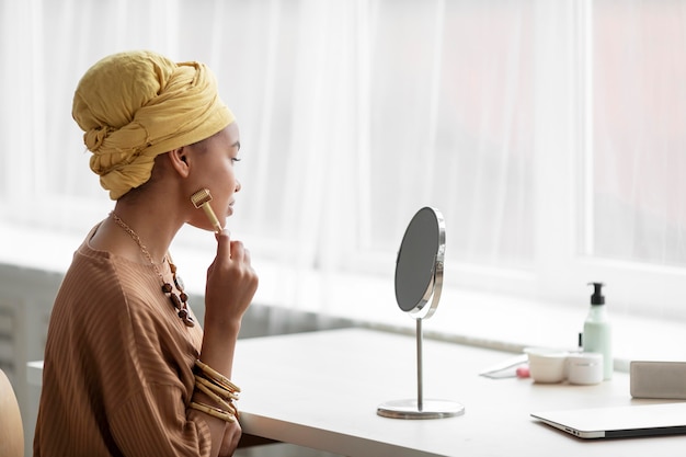 Arabische Frau mit einem Gesichtsmassagegerät. Schönheitsbehandlung