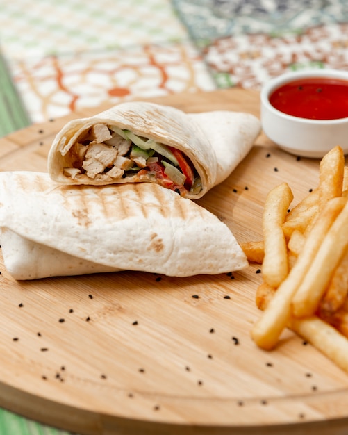 Arabische Shaurma in Lavash mit Pommes Frites und Tomatensauce.