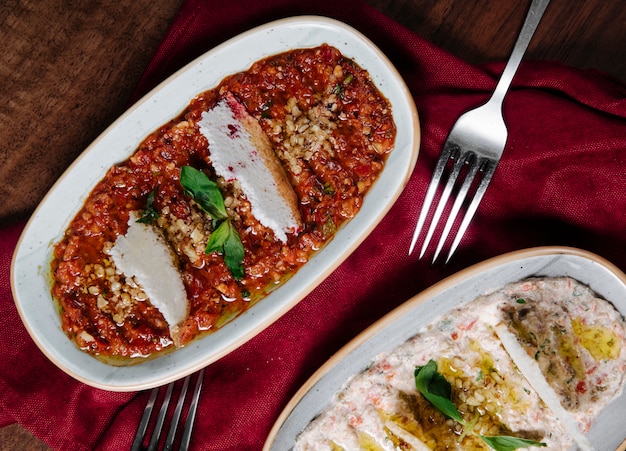 Arabischer Apetizer Humus mit Joghurt und in Tomatensauce mit Kräutern.