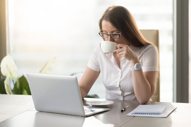 Arbeiten an trinkendem Kaffee der Computergeschäftsfrau