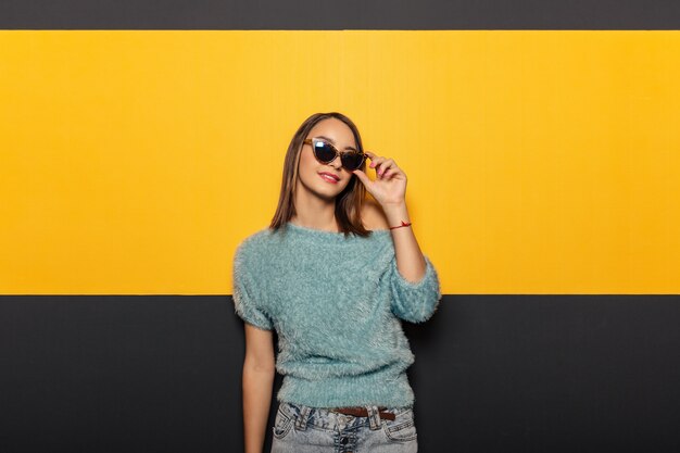 Arbeiten Sie Porträt einer anziehenden, stilvollen Frau mit Sonnenbrille um