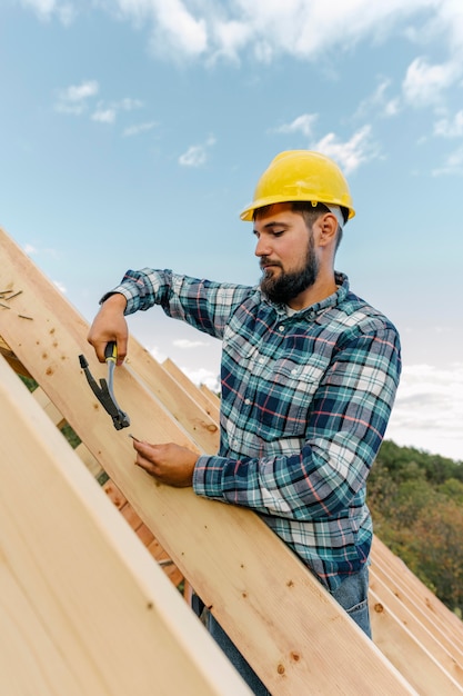 Arbeiter, der das Dach des Hauses baut