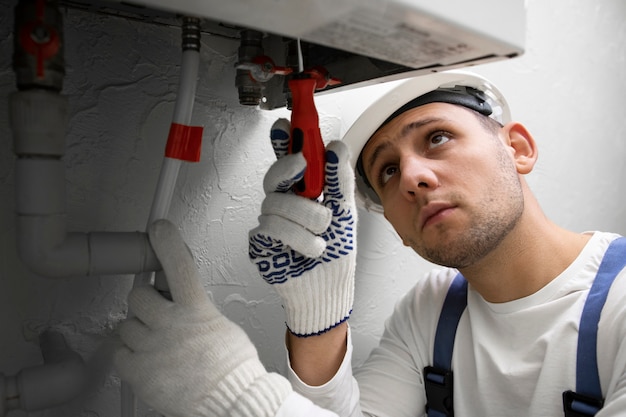 Arbeiter, der Warmwasserbereiter repariert