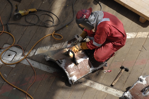 Arbeiter im Arbeitsanzug, der das Metallgestell repariert