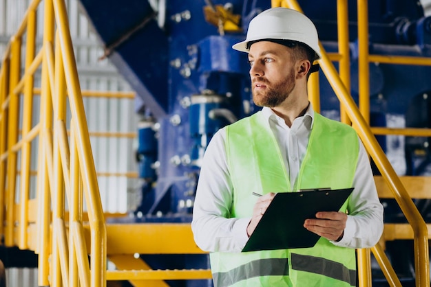 Arbeiter in einer Fabrik, der Notizen schreibt