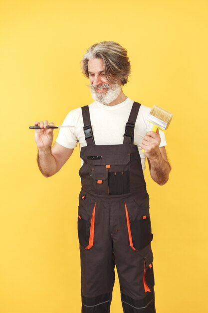 Kostenloses Foto arbeiter in overalls. mann mit werkzeugen. senior mit spatel.