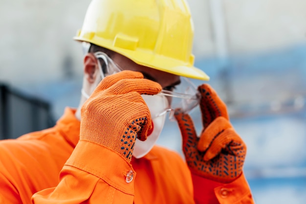 Arbeiter in Uniform mit Schutzhelm und Schutzbrille