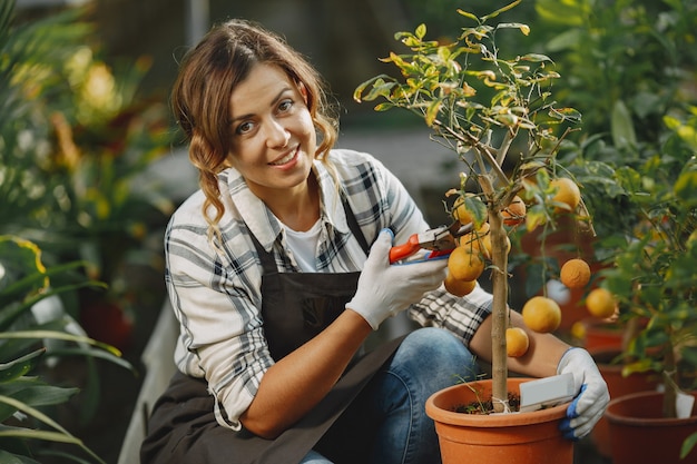 Arbeiter kümmern sich um Blumenbeete. Mädchen in einem weißen Hemd. Frau in Handschuhen