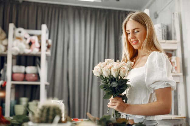 Arbeiter mit Blumen. Frau macht einen Blumenstrauß. Nettes Mädchen, das arbeitet