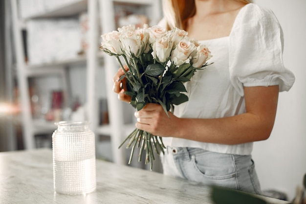 Arbeiter mit Blumen. Frau macht einen Blumenstrauß. Nettes Mädchen, das arbeitet