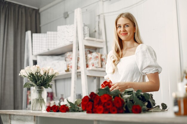 Arbeiter mit Blumen. Frau macht einen Blumenstrauß. Nettes Mädchen, das arbeitet