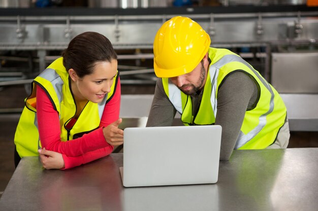 Arbeiter mit Laptop in der Fabrik