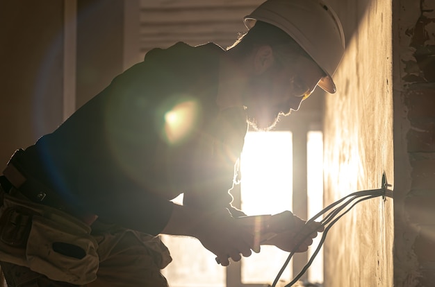 Arbeiter schneidet Drähte mit Linemans-Zange