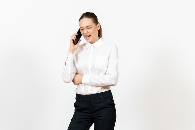 Arbeiterin in eleganter weißer Bluse, die am Telefon auf Weiß spricht